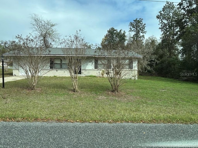 view of front of house featuring a garage, brick siding, and a front yard