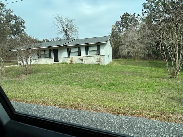 view of front of property with a front lawn and brick siding