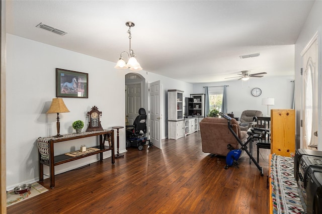 living area featuring a ceiling fan, arched walkways, visible vents, and wood finished floors