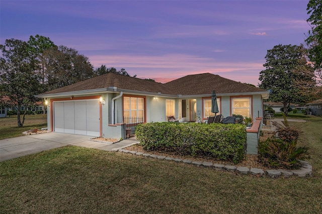 single story home featuring concrete driveway, an attached garage, a front lawn, and stucco siding