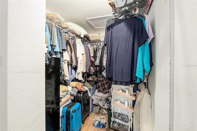 spacious closet with wood finished floors and attic access