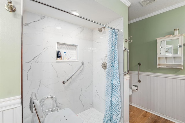 bathroom featuring a shower with curtain, a wainscoted wall, visible vents, and crown molding