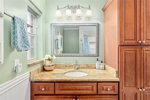 full bathroom with wainscoting and vanity