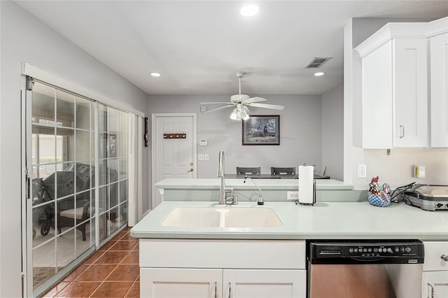 kitchen featuring a sink, dark tile patterned floors, light countertops, and stainless steel dishwasher