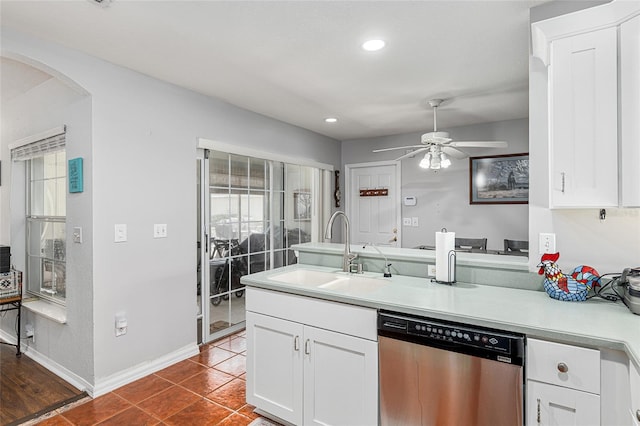 kitchen featuring light countertops, white cabinetry, a sink, dishwasher, and a peninsula