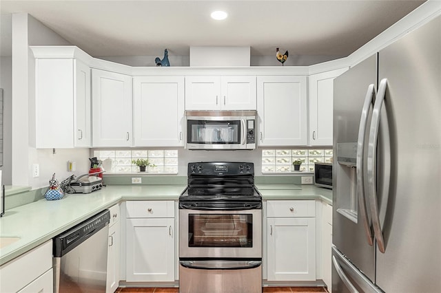 kitchen featuring appliances with stainless steel finishes, light countertops, a healthy amount of sunlight, and white cabinetry