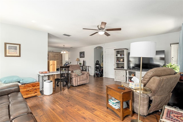 living room with arched walkways, ceiling fan, dark wood-type flooring, and visible vents