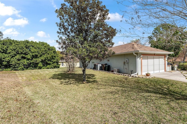 view of front facade with driveway, stucco siding, a garage, and a front yard