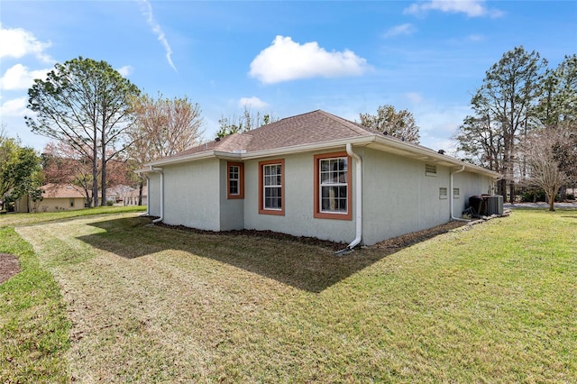 view of property exterior featuring stucco siding, roof with shingles, central AC, and a yard