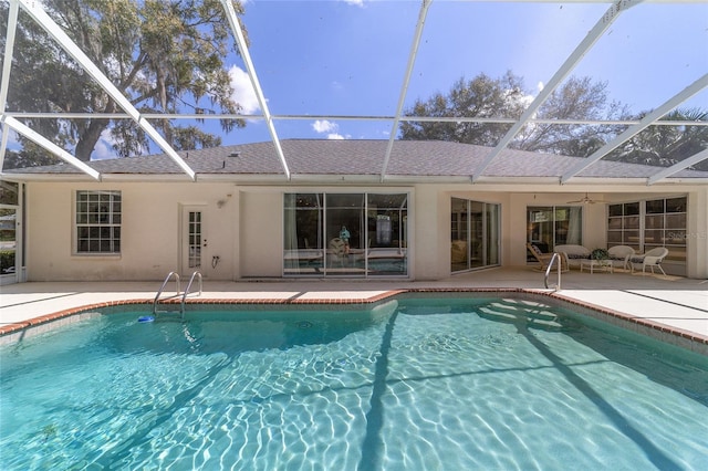 pool featuring a patio area, ceiling fan, and glass enclosure