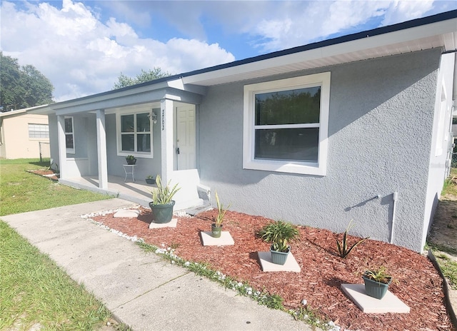 view of front facade featuring covered porch and stucco siding