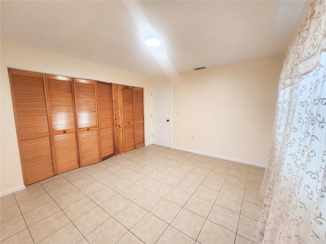 unfurnished bedroom featuring baseboards, visible vents, and a closet