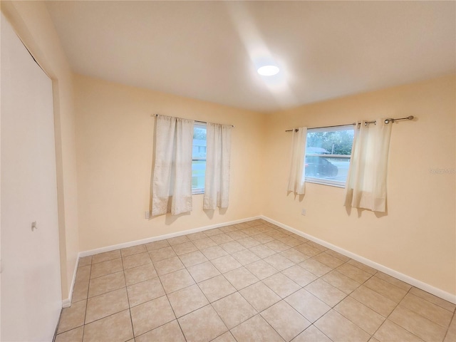 empty room featuring a healthy amount of sunlight and baseboards