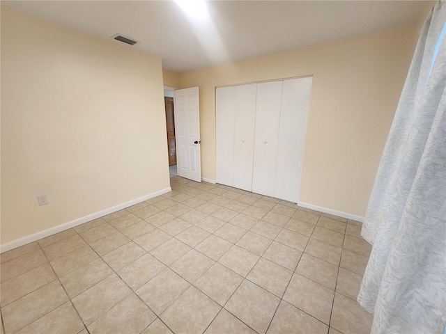 unfurnished bedroom featuring baseboards, visible vents, and a closet