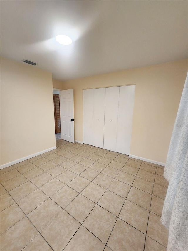 unfurnished bedroom featuring a closet, visible vents, and baseboards