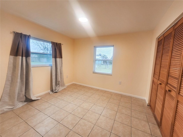 unfurnished bedroom with baseboards and a closet