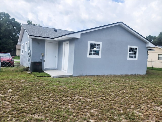 back of house featuring fence, cooling unit, and stucco siding