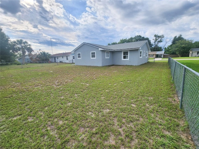 back of property with a yard, a fenced backyard, and stucco siding