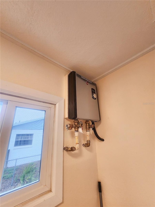 details featuring a textured ceiling, tankless water heater, and crown molding