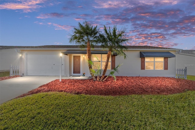 single story home with an attached garage, a front lawn, and concrete driveway