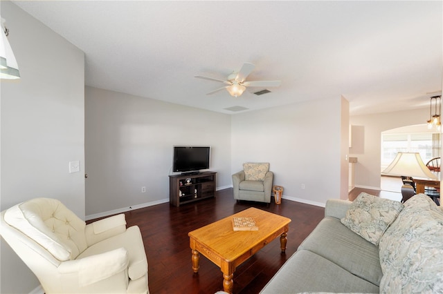 living room with a ceiling fan, dark wood-style flooring, visible vents, and baseboards