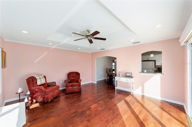 sitting room with arched walkways, ornamental molding, wood finished floors, and recessed lighting