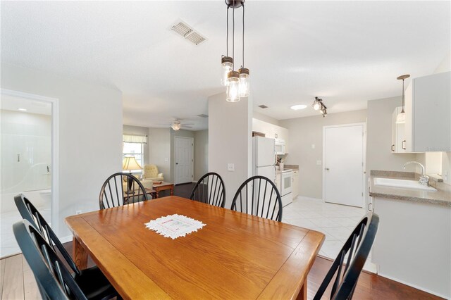 dining room with a ceiling fan, visible vents, and light tile patterned floors