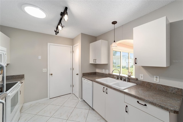 kitchen featuring a textured ceiling, white appliances, a sink, white cabinetry, and dark countertops