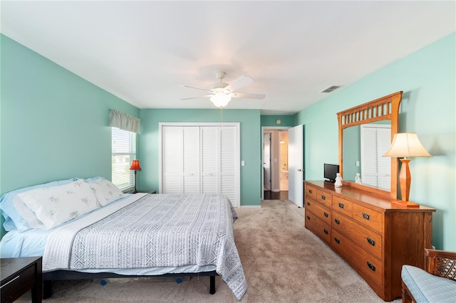 bedroom with a ceiling fan, light colored carpet, a closet, and visible vents