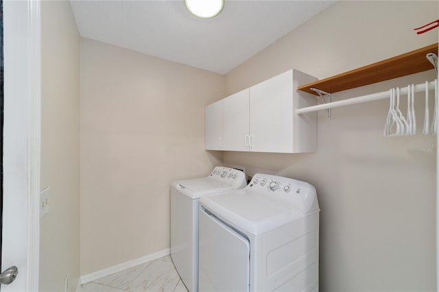 laundry area featuring cabinet space, washing machine and dryer, and baseboards