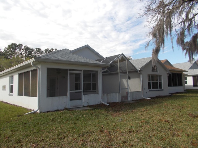 rear view of house with a sunroom and a yard