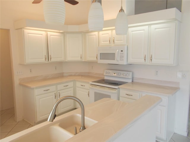 kitchen with white appliances, white cabinets, a sink, and light tile patterned flooring