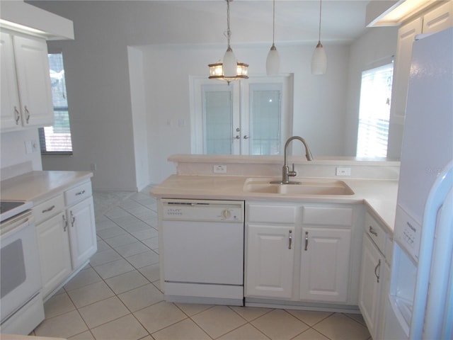 kitchen with light tile patterned floors, white appliances, a sink, and white cabinets