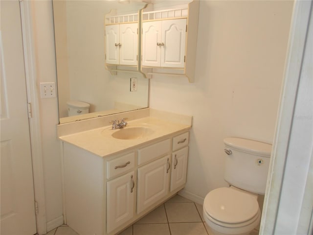 bathroom with baseboards, vanity, toilet, and tile patterned floors