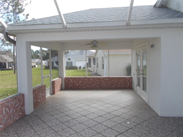 unfurnished sunroom featuring ceiling fan