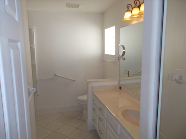 bathroom with tile patterned flooring, toilet, vanity, visible vents, and baseboards