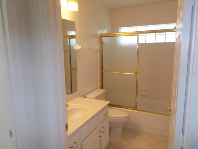 bathroom with shower / bath combination with glass door, vanity, toilet, and tile patterned floors