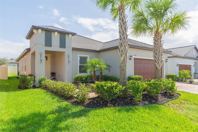 view of front of property with metal roof, a garage, decorative driveway, stucco siding, and a front lawn