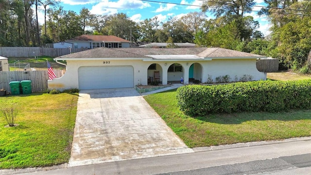 view of front of house featuring a garage, fence, concrete driveway, and a front yard