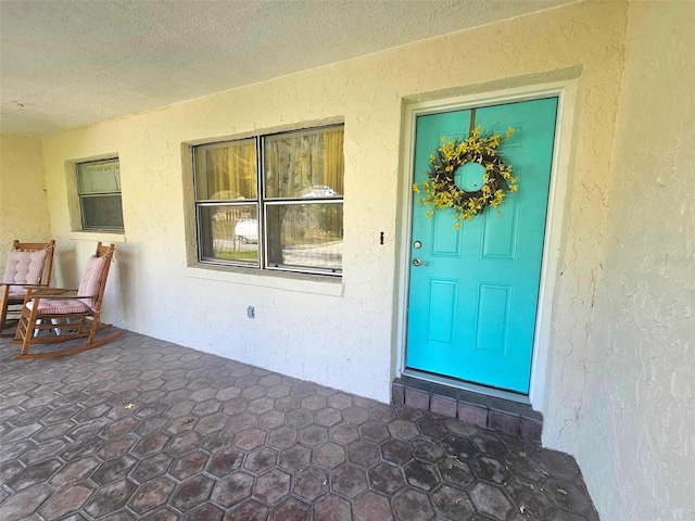 entrance to property featuring stucco siding