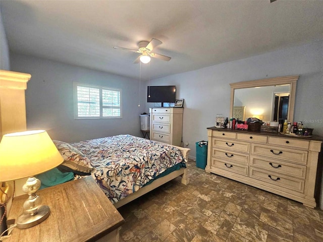 bedroom featuring stone finish flooring and a ceiling fan