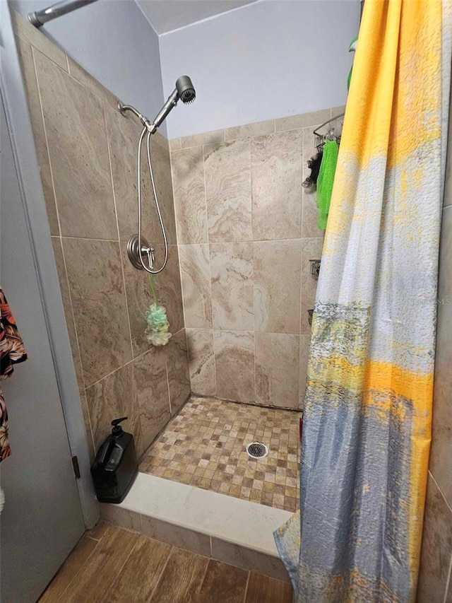 bathroom with a stall shower and wood finished floors