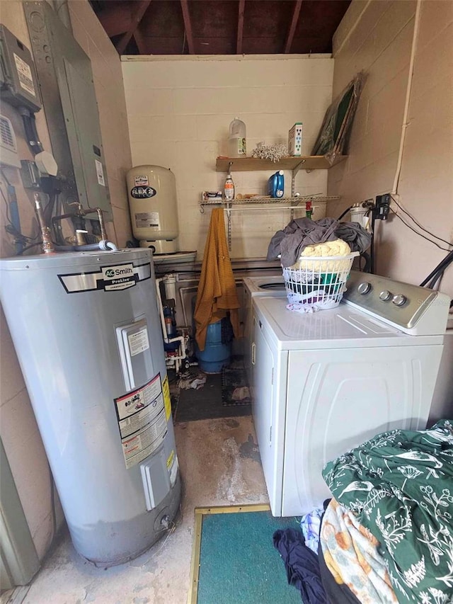 clothes washing area featuring laundry area, electric water heater, and concrete block wall