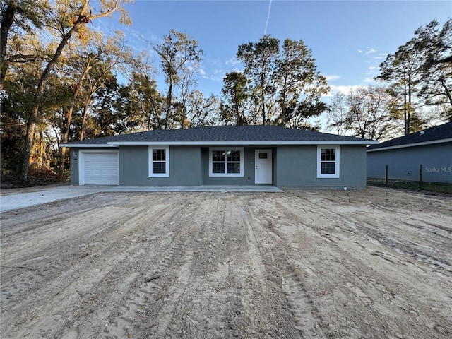 single story home featuring a garage and stucco siding