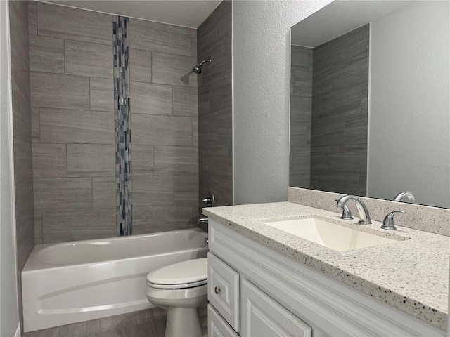 full bath with a textured wall, vanity, toilet, and shower / bathtub combination