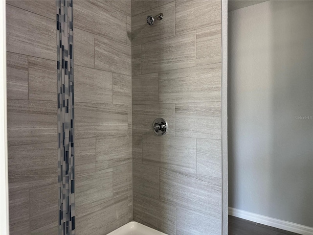 bathroom featuring baseboards and tiled shower