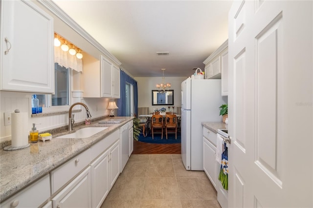 kitchen featuring visible vents, light tile patterned flooring, a sink, white cabinets, and white appliances