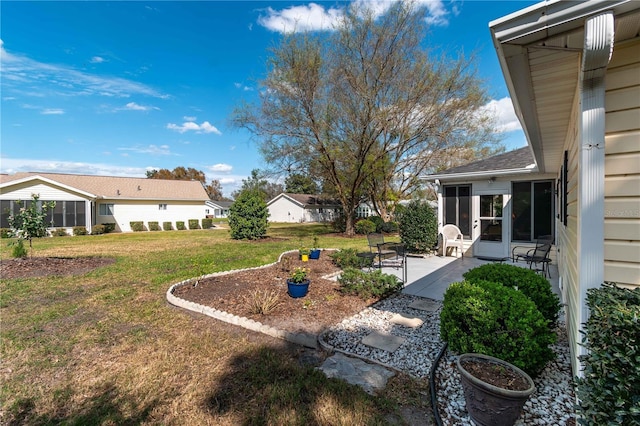 view of yard with a sunroom and a patio area