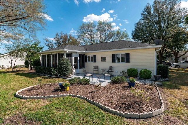 rear view of property featuring a yard, a sunroom, and a patio