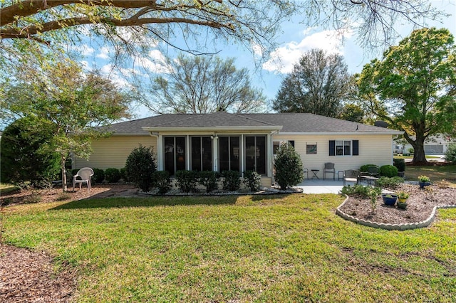 back of property featuring a patio, a yard, and a sunroom